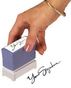 A hand holding a stamp that leaves your signature