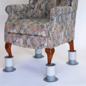 Image is a photograph of a patterned, fabric armchair with leg raisers