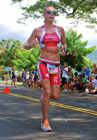 Image of Caroline Steffan wearing red sportswear and orange greeper laces, running outdoors in Kona