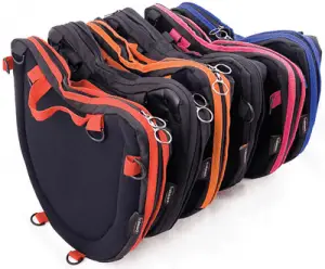 Image shows a photograph of Trabasack Curve bags in various trim colours, stood on end and lined-up one behind another