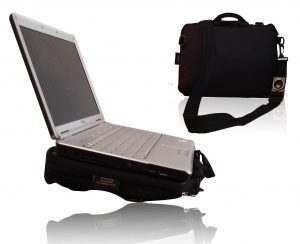 Image shows a photograph of the Trabasack Mini with a laptop on the tray surface