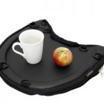 Image shows a photograph of the Trabasack Curve with a cup and an apple on top of the tray surface, on a white background