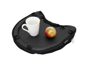Image shows a photograph of the Trabasack Curve with a cup and an apple on top of the tray surface, on a white background